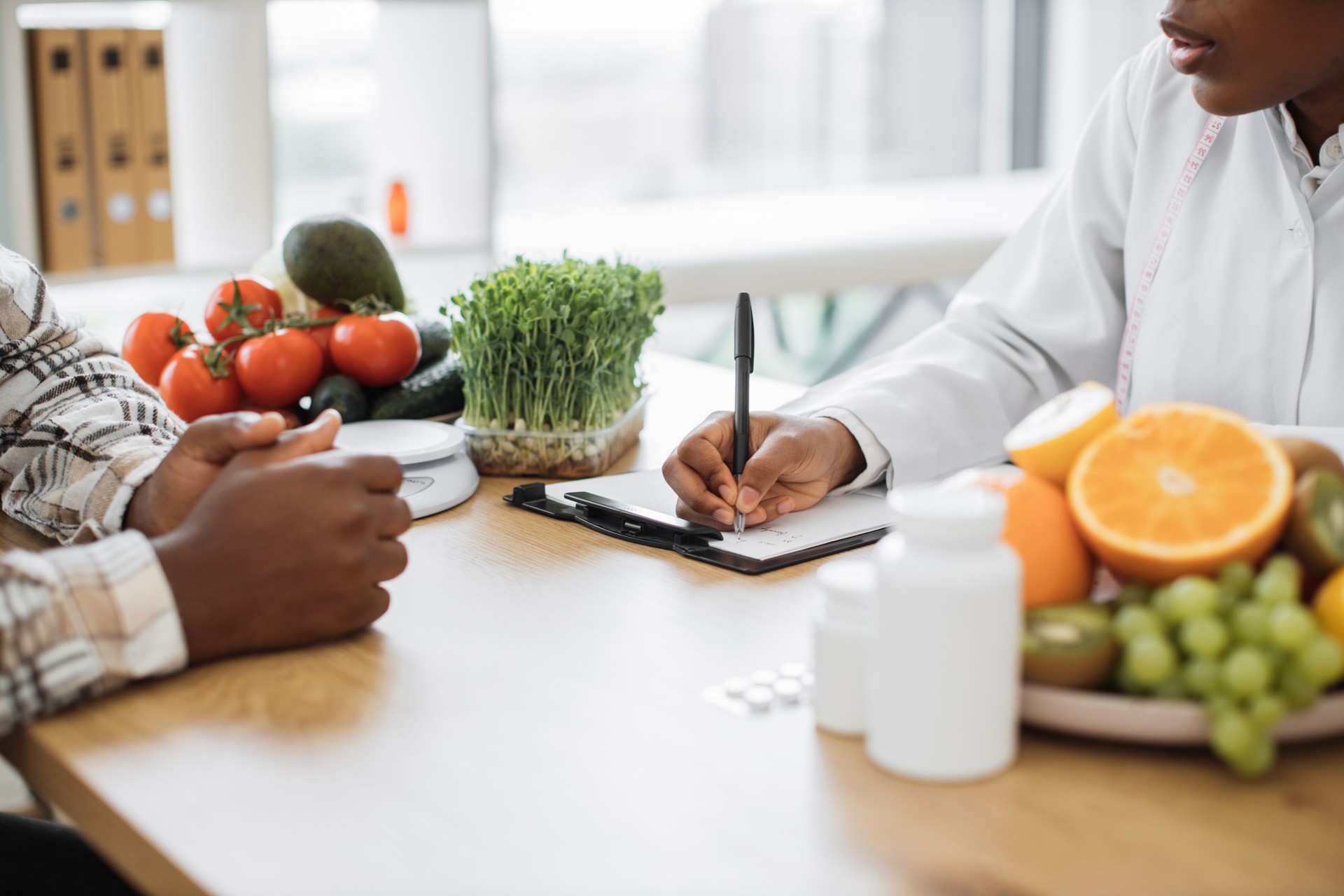 Nutritionist making notes at desk with medicine and products